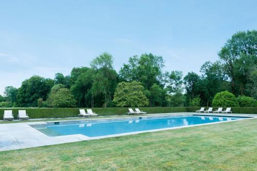 a swimming pool with lounge chairs in a yard at Château de Perreux, The Originals Collection in Amboise