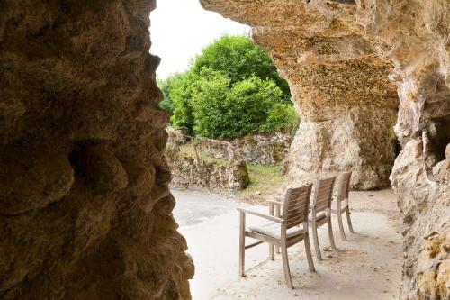 a group of chairs sitting inside of a cave at Château de Perreux, The Originals Collection in Amboise