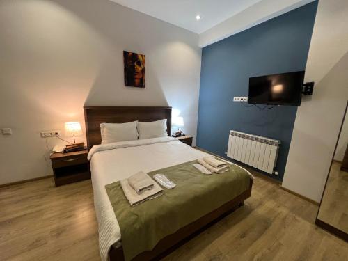 a bedroom with a bed with two towels on it at Hotel King Tom in Tbilisi City