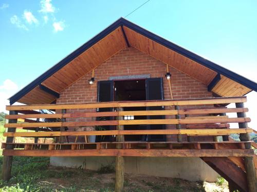 a brick building with a roof with a window at Chalé Sítio São José in Santo Antônio do Pinhal