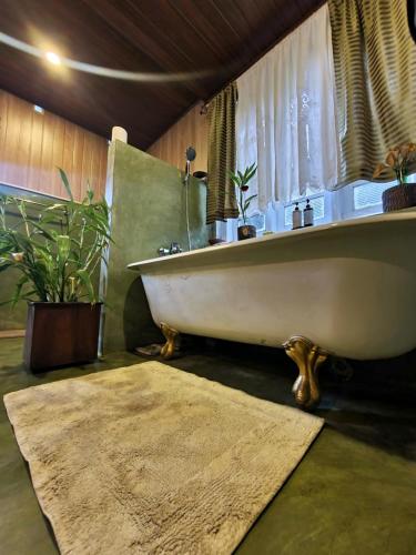 a bath tub sitting in a bathroom with a rug at Galkanda Walawwa in Kandy