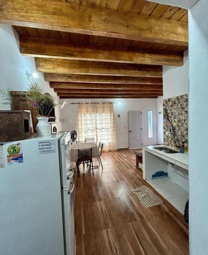 a kitchen and dining room with a refrigerator and a table at Gobernador Roca Duplex in Gobernador Roca