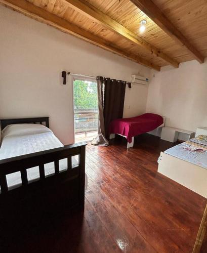 a bedroom with a bed and a window and a table at Gobernador Roca Duplex in Gobernador Roca