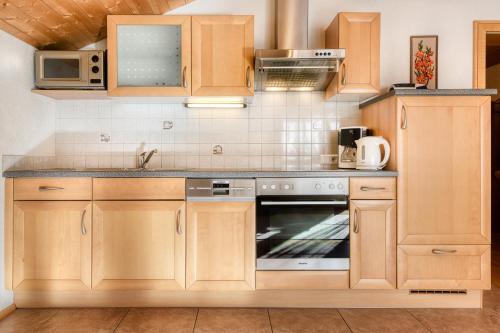 eine Küche mit Holzschränken und einem Backofen in der Unterkunft Haus Alvier by A-Appartments in Brand