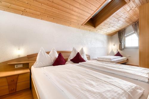 1 Schlafzimmer mit 2 Betten und roten Kissen in der Unterkunft Haus Alvier by A-Appartments in Brand