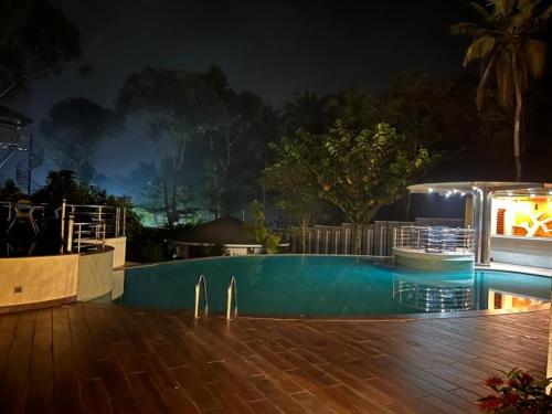 a swimming pool at night with aperaturebestosbestosbestosbestosbestosbestosbestosbestos at Michael Leisure & Ayurveda Retreat in Trivandrum
