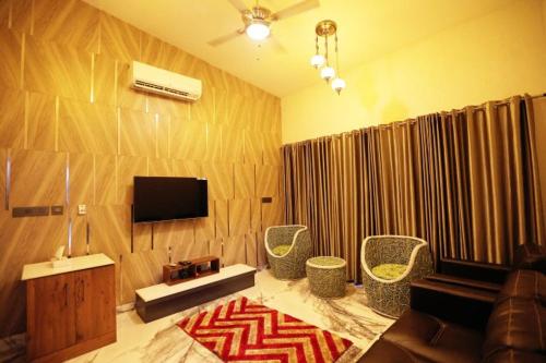 a living room with a couch and chairs and a television at Michael Leisure & Ayurveda Retreat in Trivandrum