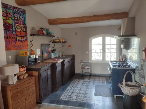 - une cuisine avec des placards en bois et une cuisinière bleue dans l'établissement Loft Tourtour, à Tourtour