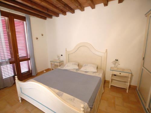 a bedroom with a white bed and a table at Villaggio Di Mezzo Ortano in Rio Marina