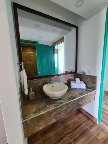 baño con lavabo y espejo grande en LA ALBACEA, en Quimbaya