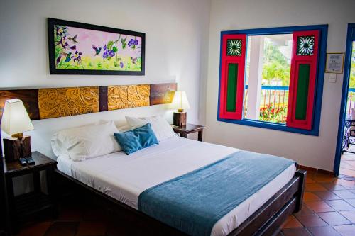 1 dormitorio con 1 cama y 2 ventanas en LA ALBACEA, en Quimbaya