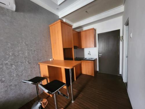 una pequeña cocina con escritorio y 2 sillas en Metro Suits Apartment Bandung en Bandung