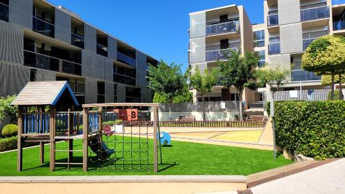 a playground in front of a apartment building at Entre el mar y PortAventura 2 in Salou