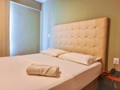 a bedroom with a bed with a towel on it at Ilusion Flat Ponta Negra in Natal