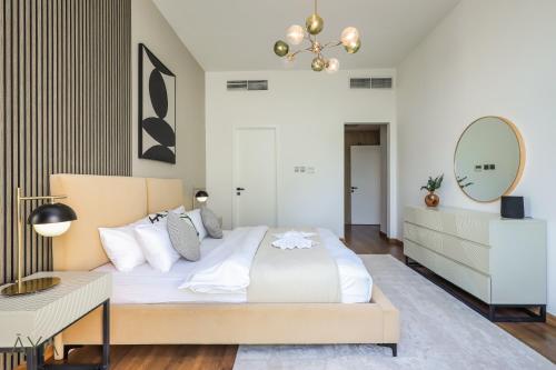 a bedroom with a large bed and a mirror at AYA Boutique - Oasis in Al Muntazah 3BR Villa with Private Pool in Abu Dhabi