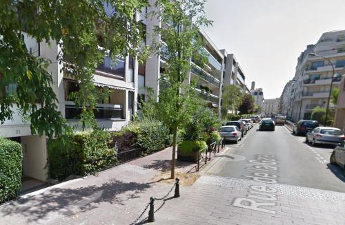 a street with cars parked on the side of the road at Magnifique Appartement, 3 min de Paris in Levallois-Perret