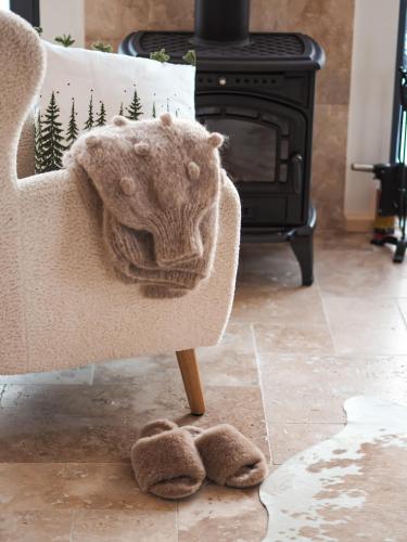 a blanket on a chair in front of a fireplace at Owczarnia Tatry in Bukowina Tatrzańska