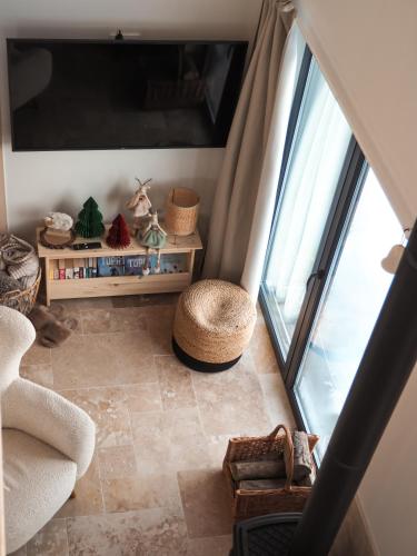 a living room with a large window and a chair at Owczarnia Tatry in Bukowina Tatrzańska