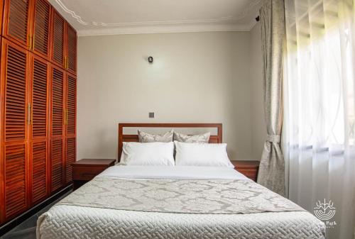 um quarto com uma cama grande e uma janela em Lyons Park Apartments. em Bulindo