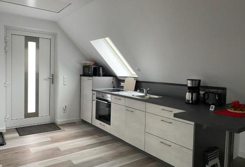 uma cozinha com um lavatório e um fogão forno superior em Ferienhaus Helfert FeWo2 em Niemtsch