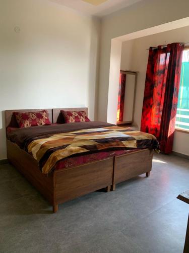 a large bed in a bedroom with red curtains at Modern Comforts with a view in Dehradun