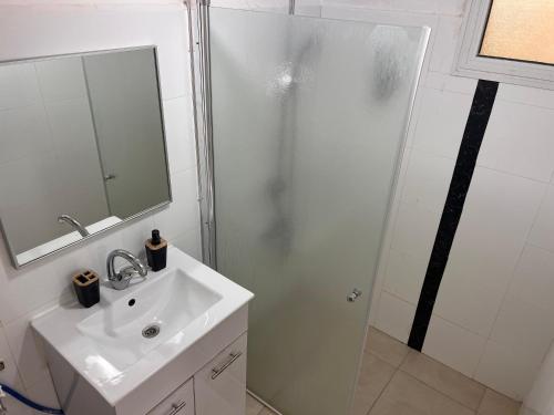 La salle de bains blanche est pourvue d'une douche et d'un lavabo. dans l'établissement Duchess of the Dead Sea by CROWN, à Neve Zohar