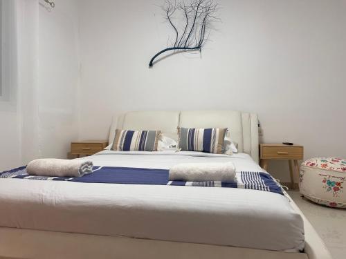 a bedroom with a large bed with blue and white pillows at Duchess of the Dead Sea by CROWN in Neve Zohar