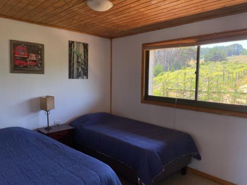 a bedroom with two beds and a window in it at vista al mar curanipe cabaña/casa in Curanipe