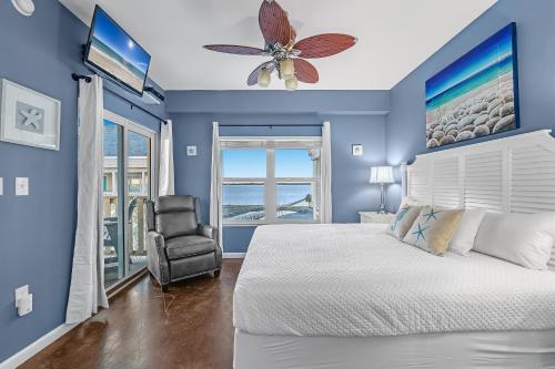 um quarto azul com uma cama e uma cadeira em Baywatch Unit H5 em Pensacola Beach