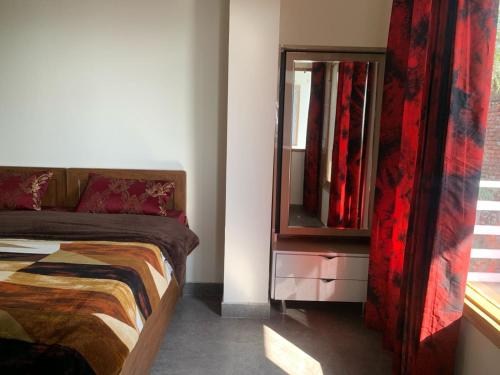 a bedroom with a bed and a dresser with a mirror at Modern Comforts with a view in Dehradun