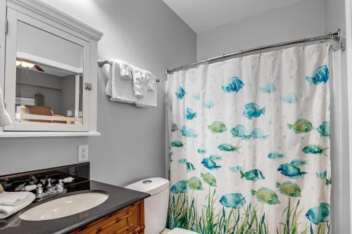 uma casa de banho com uma cortina de chuveiro com peixe em Baywatch Unit H5 em Pensacola Beach