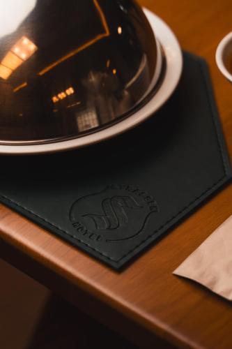 a black napkin with a plate on a table at Strassen Hotel in Goiânia