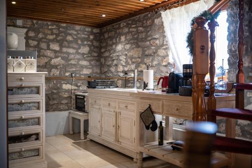 a kitchen with a counter and a stone wall at Gorianades Traditional House in Gorianádhes