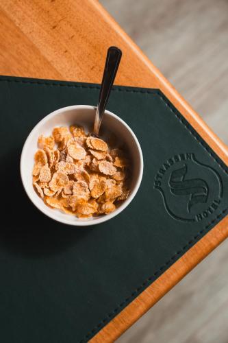 a bowl of cereal with a spoon sitting on a table at Strassen Hotel in Goiânia