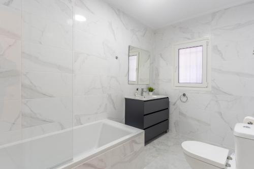 baño blanco con bañera y aseo en Beautiful 5 Bedroom Villa, Sea Views, Private Pool, Estepona newly refurbished, en Estepona