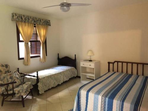 1 Schlafzimmer mit 2 Betten, einem Stuhl und einem Fenster in der Unterkunft Casa na Serra incrivel com vista para as montanhas in Petrópolis