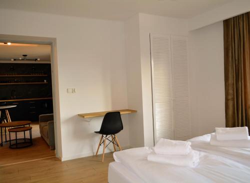 a bedroom with two beds and a table and a chair at Leśna Muzyka Apartment Limanowa in Limanowa
