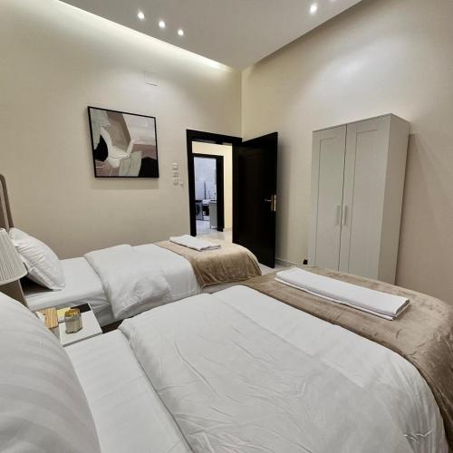 a bedroom with two beds and a mirror at منتجعات رغيد الفندقية in Hail