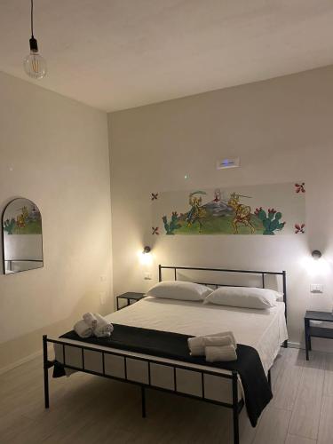 a bedroom with a bed and a painting on the wall at La Casa di Rinaldo in Catania