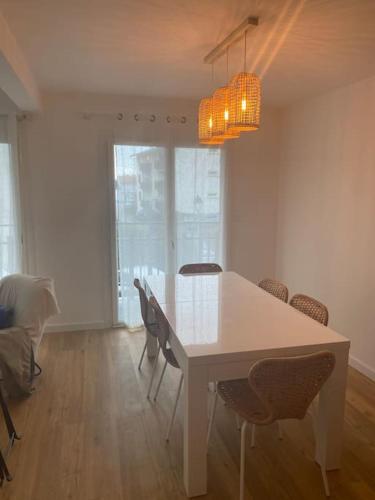 une salle à manger avec une table et des chaises blanches dans l'établissement Grand T4 - 6 couchages près du lac de Soustons face aux arènes, à Soustons
