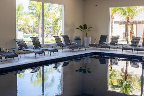 a group of chairs sitting next to a swimming pool at Vinhedo Plaza Hotel in Vinhedo