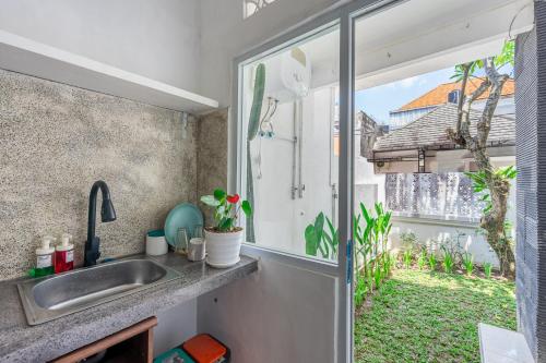 a kitchen with a sink and a window at MONA NEST Canggu 2BR Tiny House with Rooftop and Cozy Workspace in Dalung