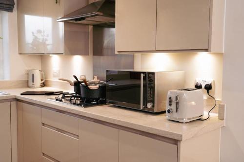 um balcão de cozinha com um micro-ondas e uma torradeira em Luxury 4Bed Townhouse - Parking+Wi-Fi+Amenities em Nuneaton