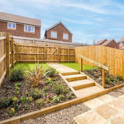 a backyard with a wooden fence and stairs at Luxury 4Bed Townhouse - Parking+Wi-Fi+Amenities in Nuneaton
