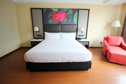 a bedroom with a bed and a red couch at Hilton Garden Inn Lima Surco in Lima