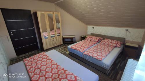 "ハルカーニャ"にあるApartman Anikó Vendégházの小さな部屋で、ベッド2台、鏡が備わります。