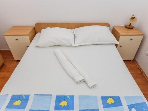 1 cama con sábanas y almohadas blancas y 2 mesitas de noche en Apartments Stef, en Marina