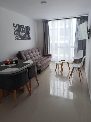 ein Wohnzimmer mit einem Sofa und einem Tisch in der Unterkunft Apartamento Hogar fuera de casa in Armenia
