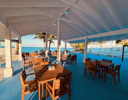 un restaurante en la playa con mesas y sillas en Exuma Palms Resort, en Hermitage