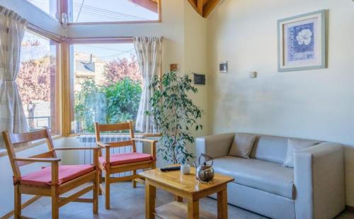 a living room with a couch and chairs and a table at Del Sur Apart in Esquel